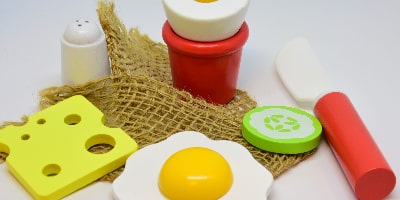 La imagen muestra alimentos de juguete: queso, huevo, sal y pepino