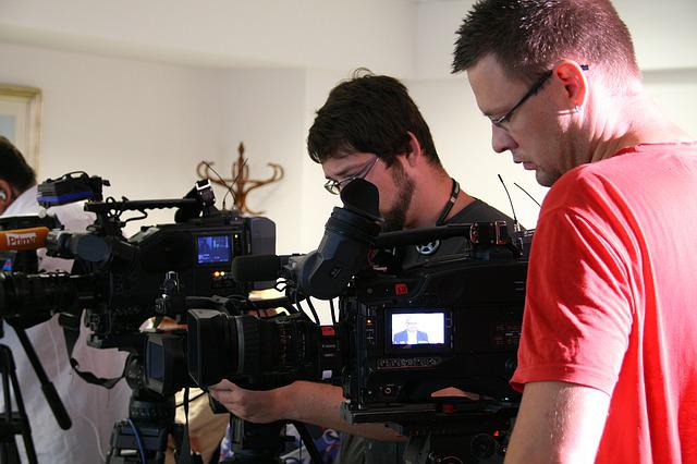 Periodista y cámara preparando una rueda de prensa.